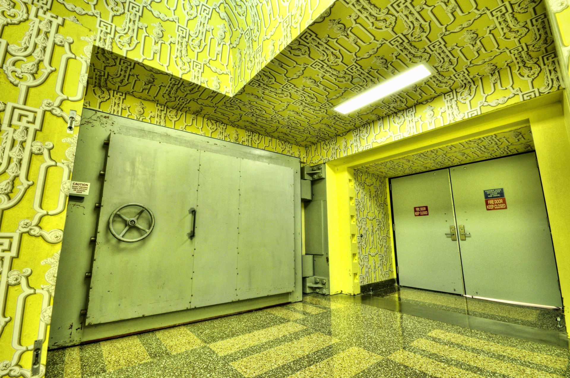 A massive steel blast door inside the Greenbrier bunker, set against the patterned walls of an exhibit hall area still used by resort guests