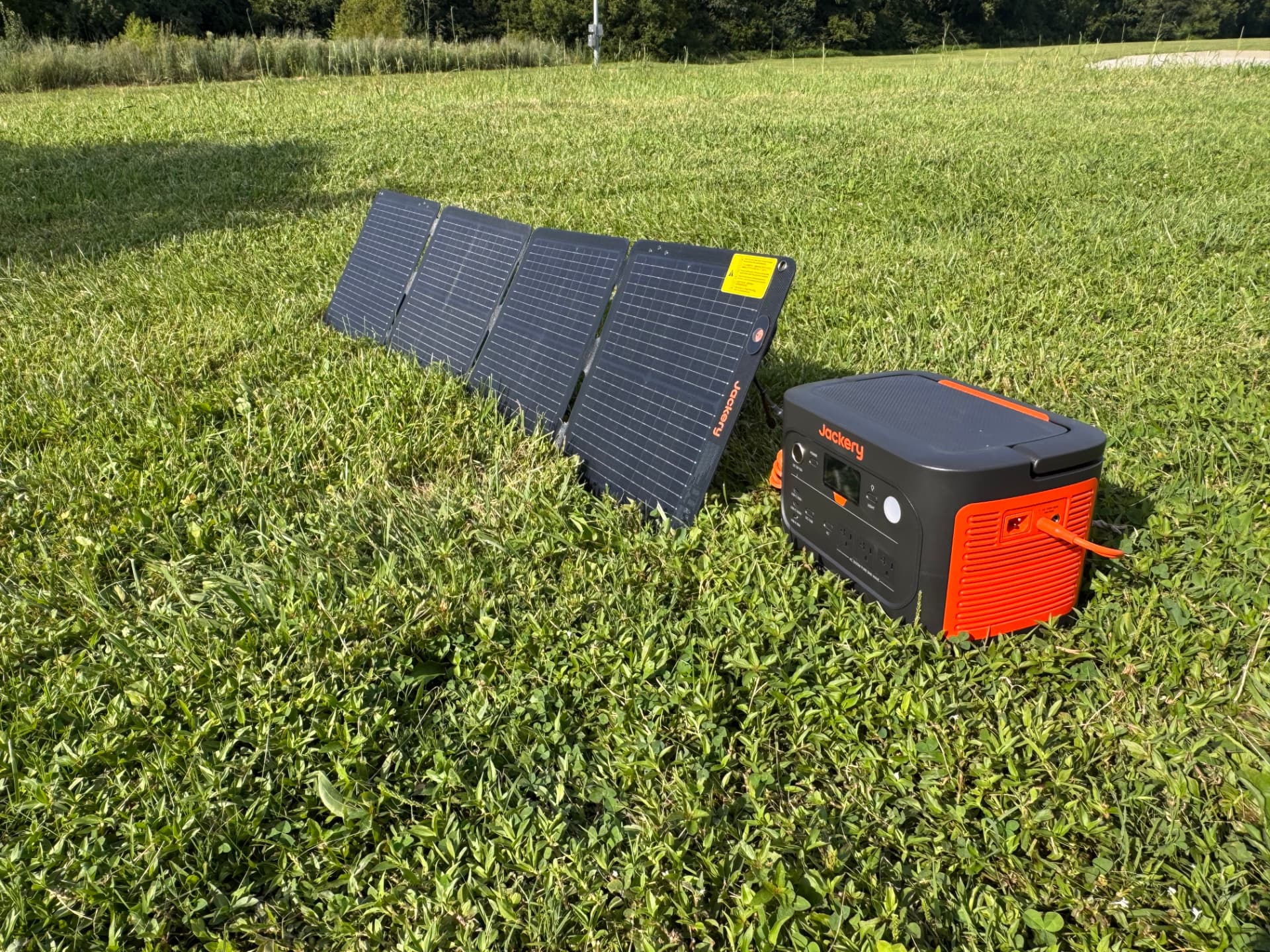 Portable Jackery solar panels arranged beside an Explorer 1500 power station in a field
