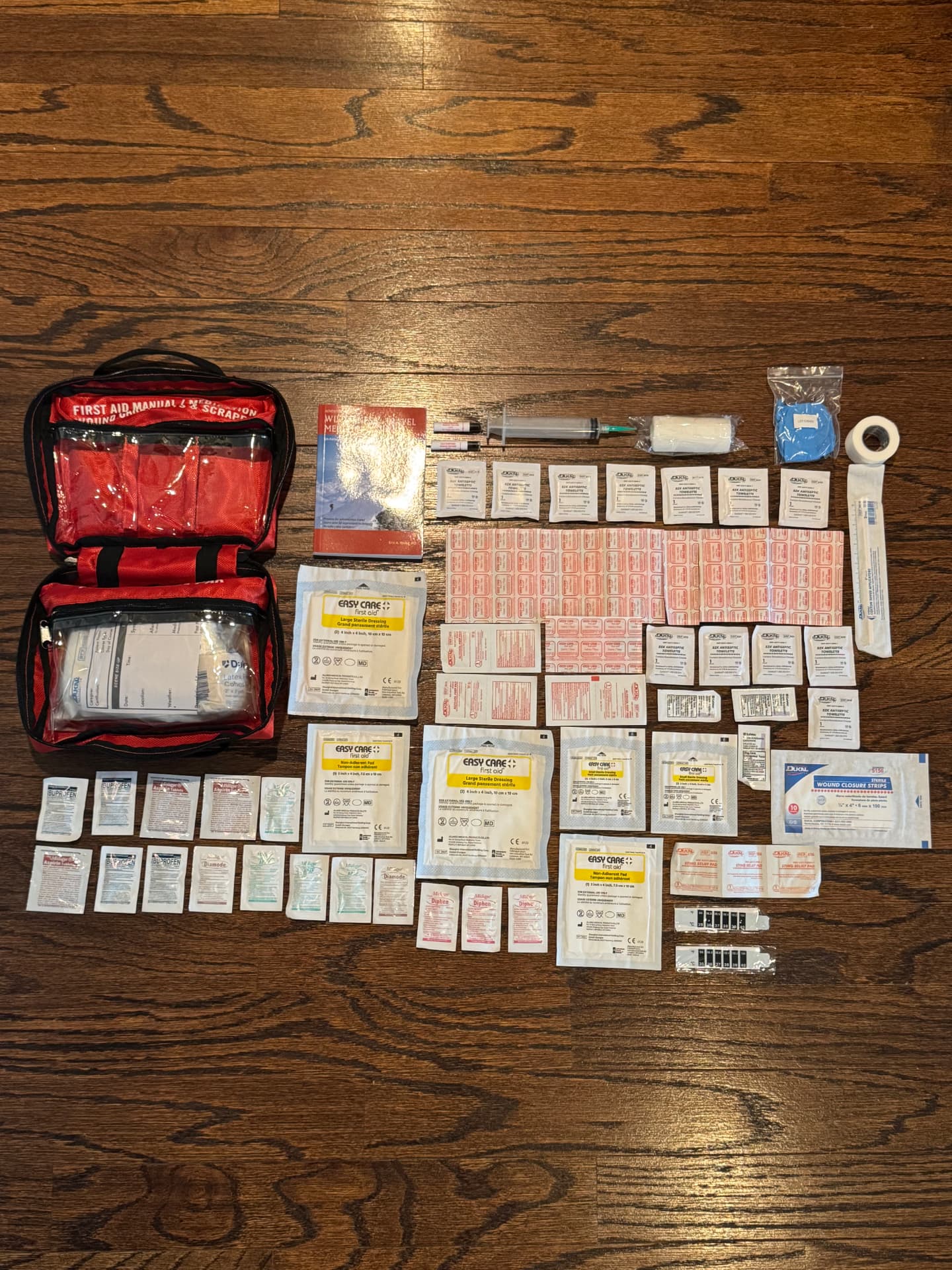 Full contents of the Sportsman 300's top pocket laid out on a wood floor