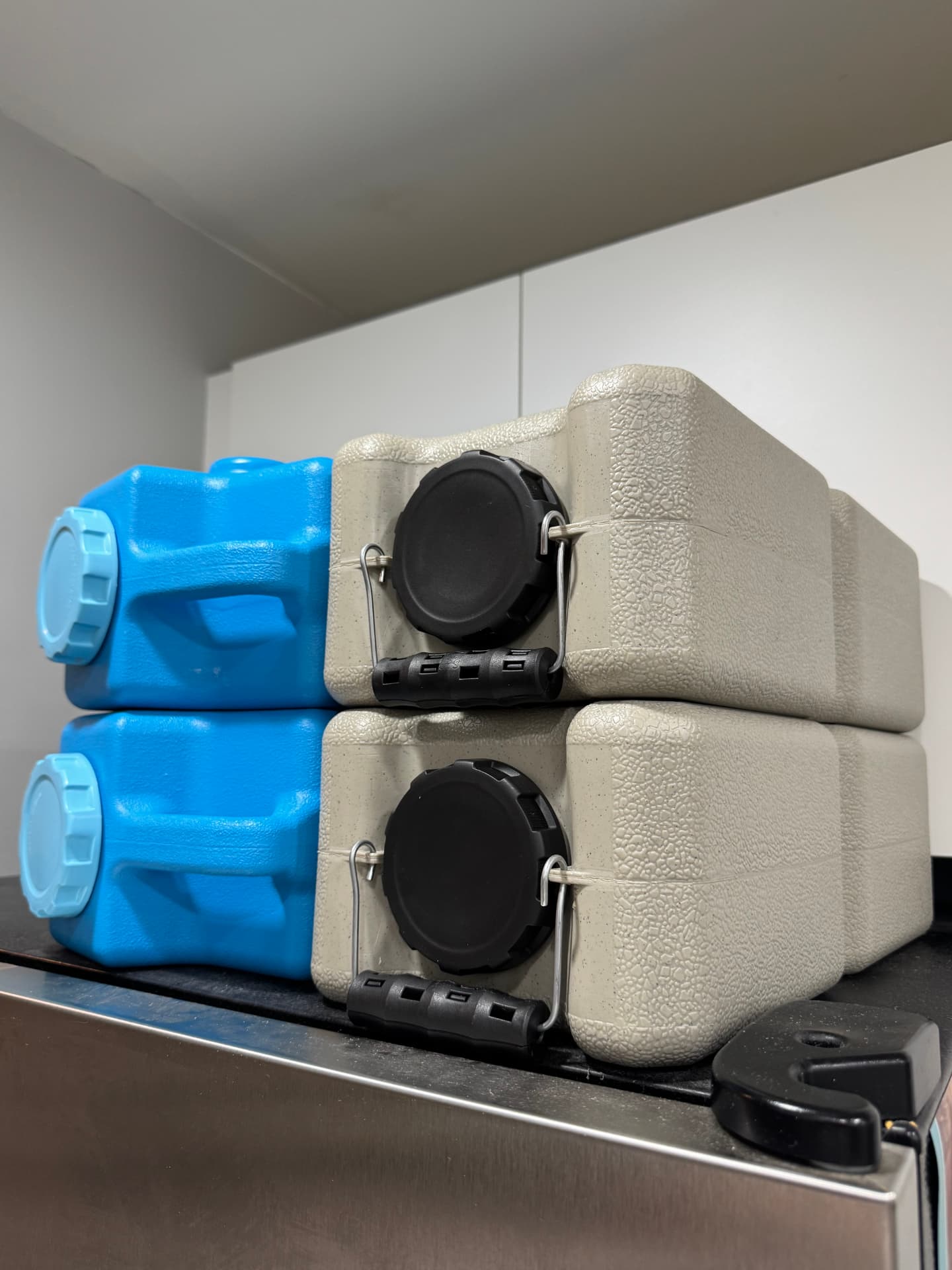 Blue AquaBrick and earth-tone WaterBrick containers stacked two high on a shelf