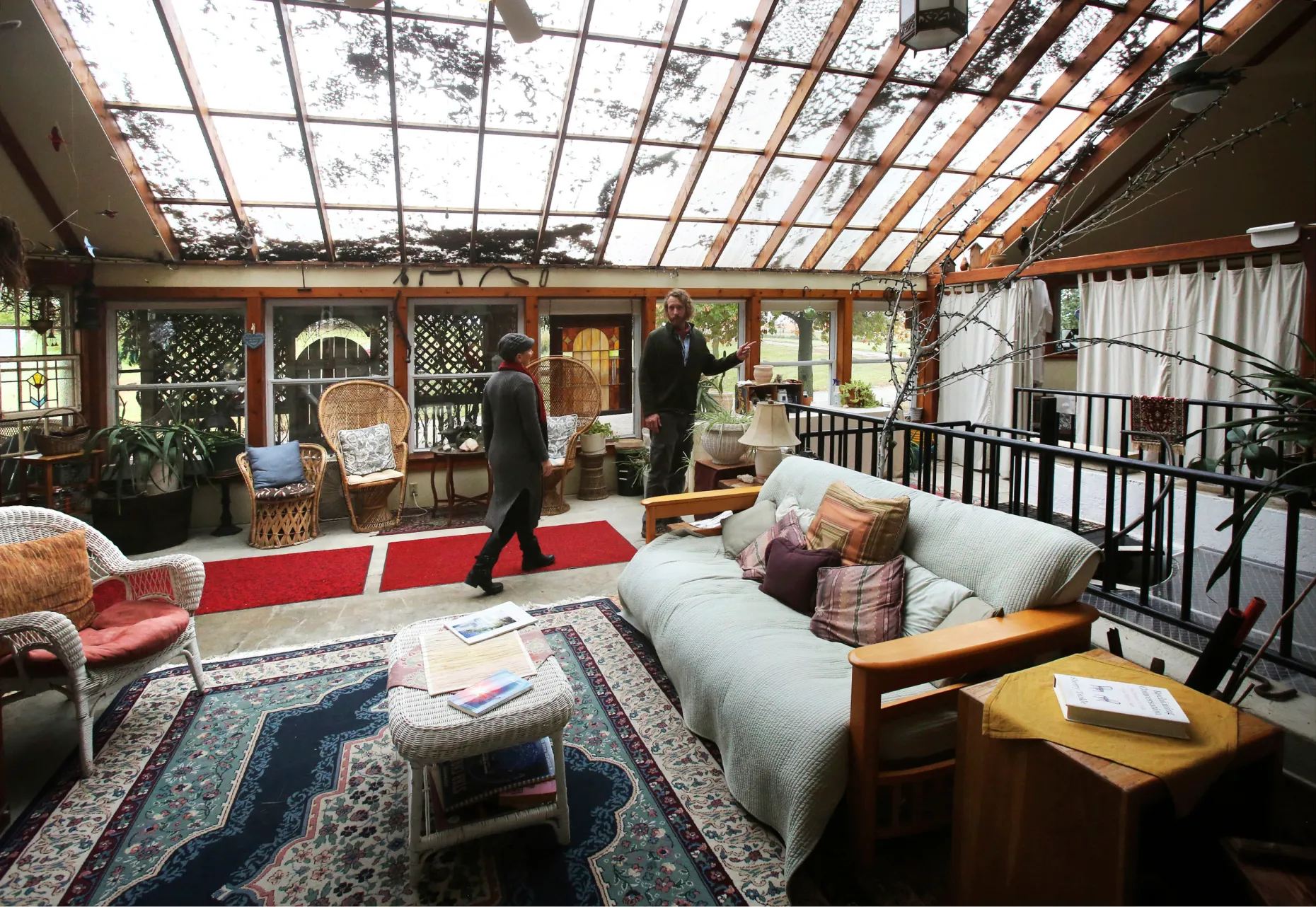 Glass-roofed solarium living space at Subterra Castle furnished with rugs, plants and seating