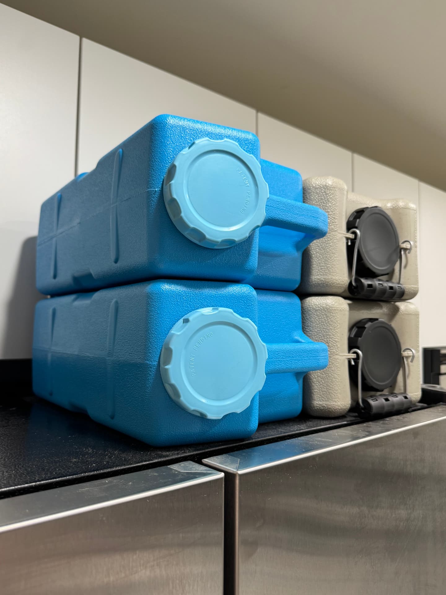 Close-up of the wide light-blue screw caps on two stacked AquaBrick containers