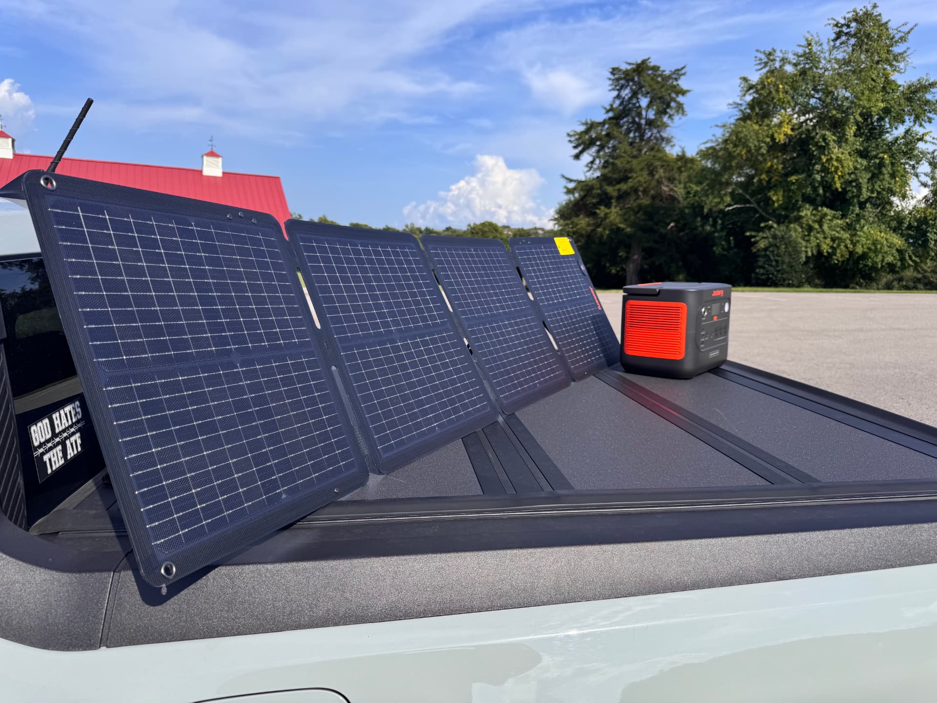 Four folding solar panels set up on a truck bed beside a Jackery Explorer 1500