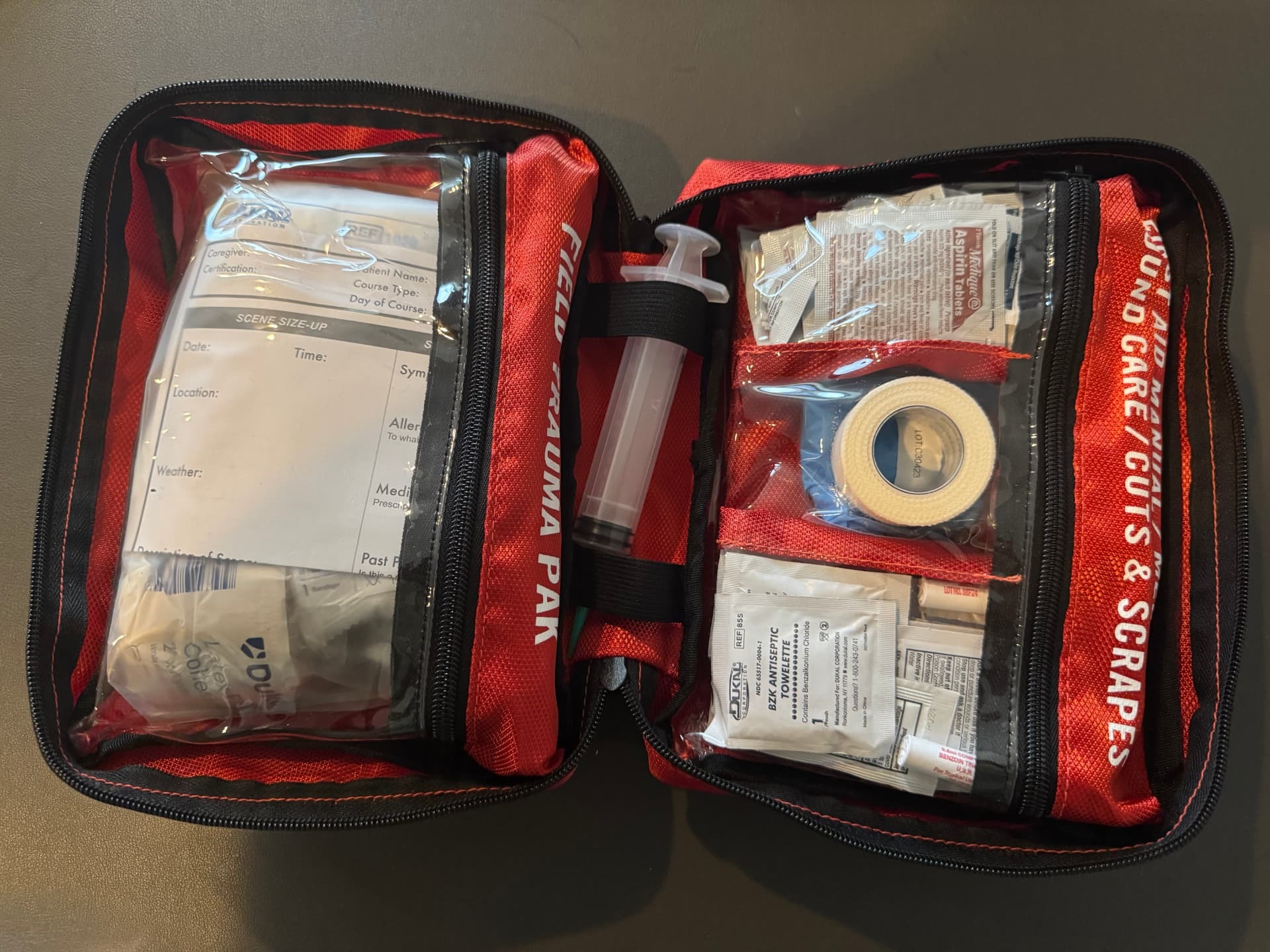 Sportsman 300 opened showing labeled compartments for wound care, cuts and scrapes, and the field trauma pack